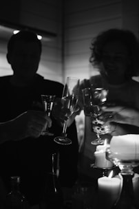 man in black crew neck shirt holding clear wine glass