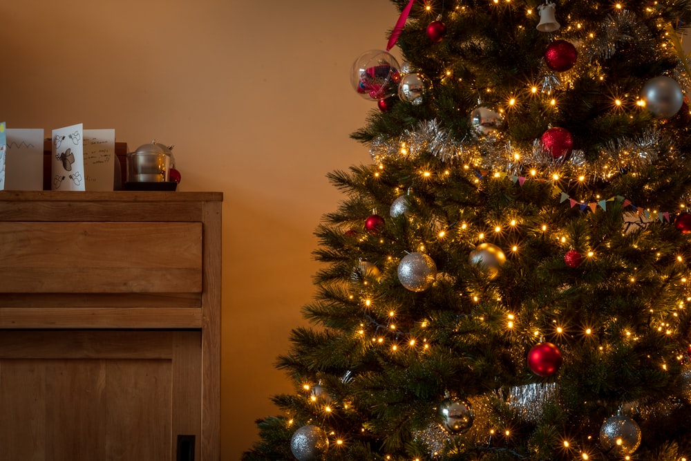 Grüner Weihnachtsbaum mit roten Kugeln und Lichterketten