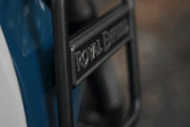 Close-up of a Royal Enfield logo on a shiny motorcycle fuel tank.