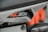 A close-up view of a motorcycle part featuring the model name RC 200 in bold white and orange text on a black background. The surrounding area appears to be part of the motorcycle's frame and components, with visible screws and a portion of orange piping or framework.