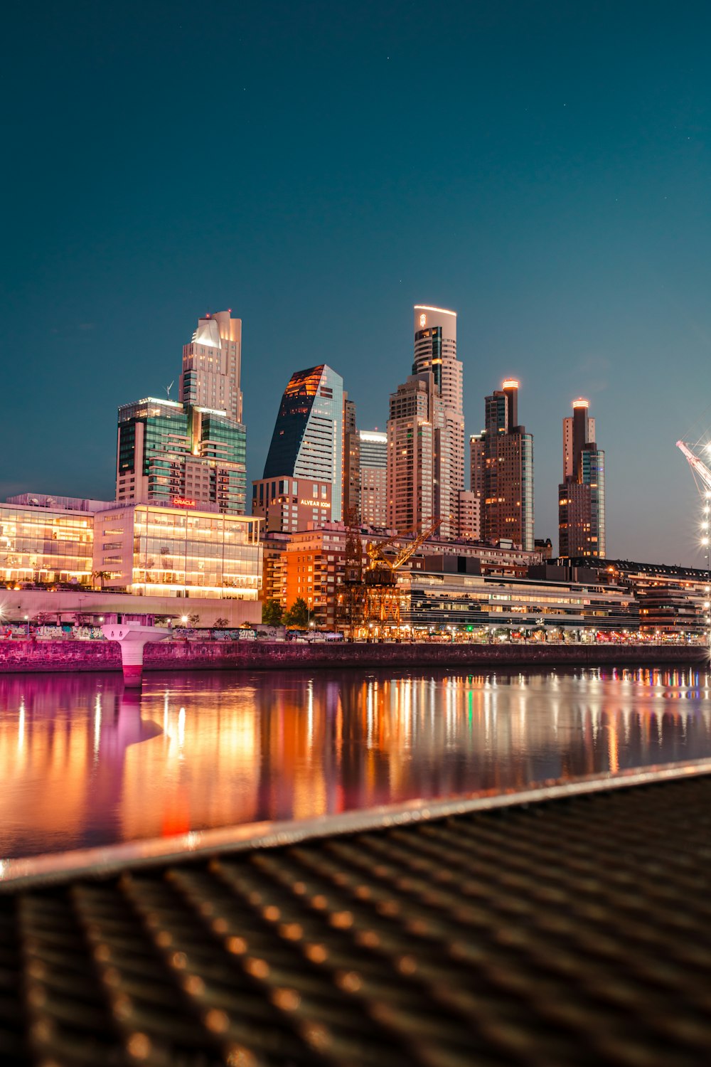 city skyline across body of water during night time