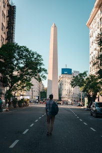 man in black jacket walking on pedestrian lane during daytime