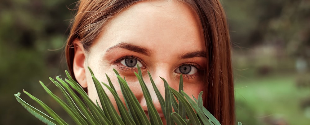 womans face with green leaves