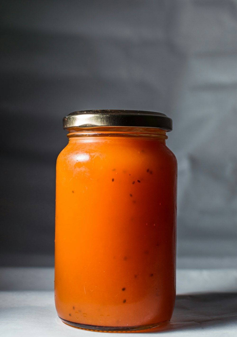 orange liquid in clear glass jar