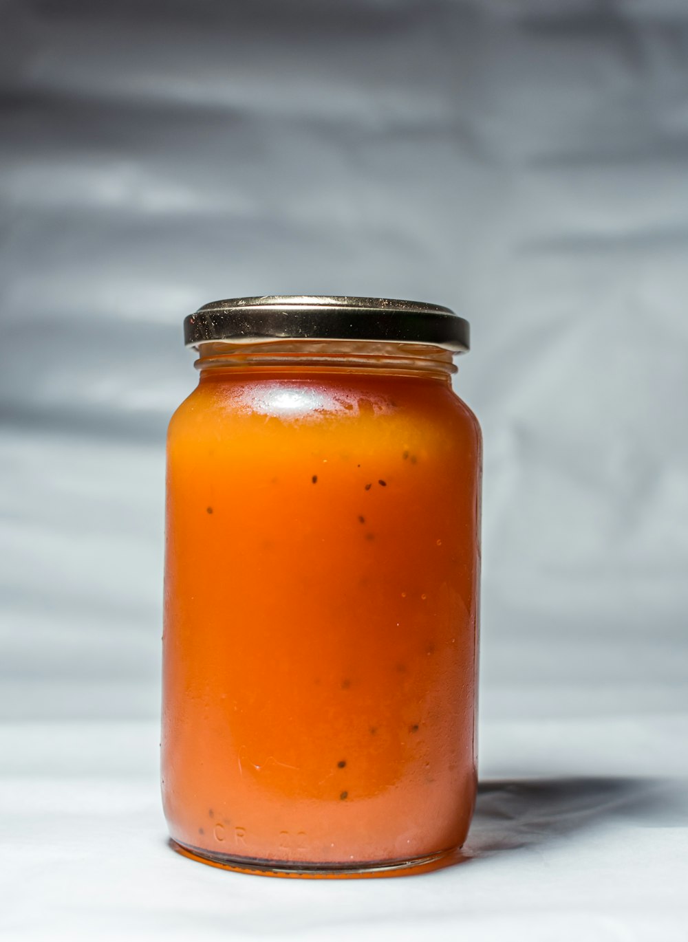 orange liquid in clear glass jar