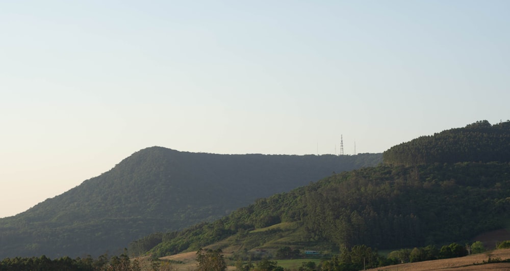 montaña verde bajo el cielo blanco durante el día