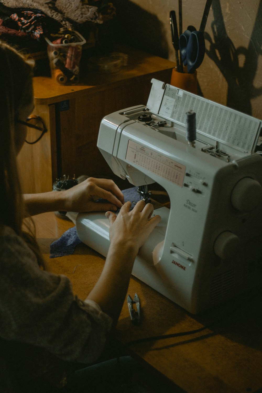 person using white sewing machine