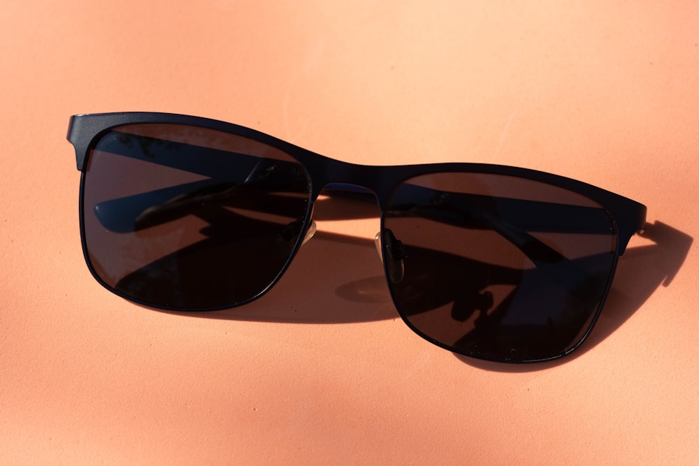 black framed sunglasses on white table