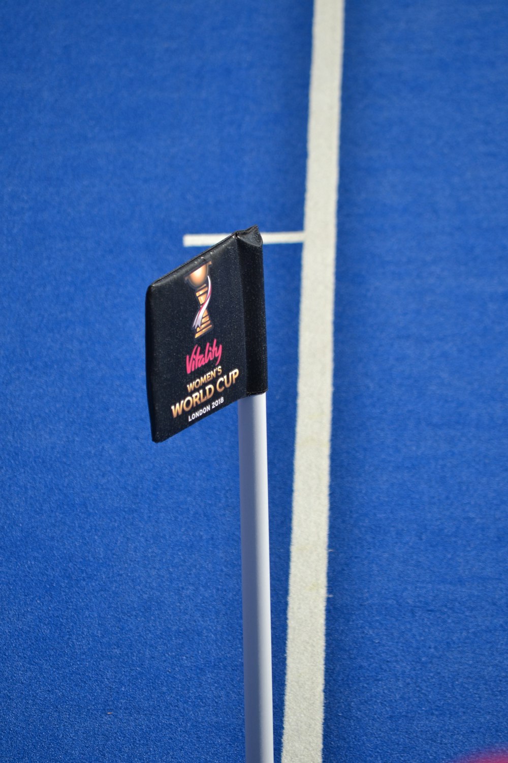 a sign on a pole on a blue court