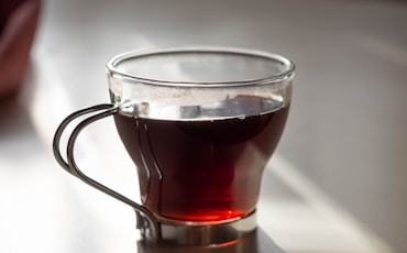 clear glass mug with brown liquid