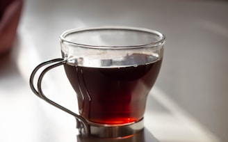 clear glass mug with brown liquid