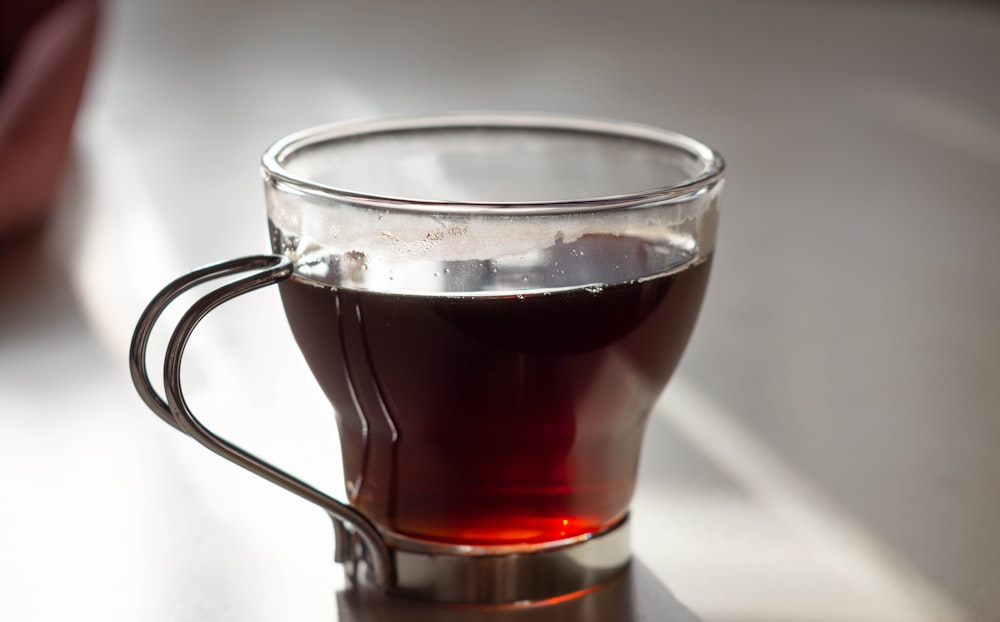 clear glass mug with brown liquid