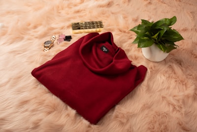 A cozy sweater folded neatly beside matching gloves and a beanie.