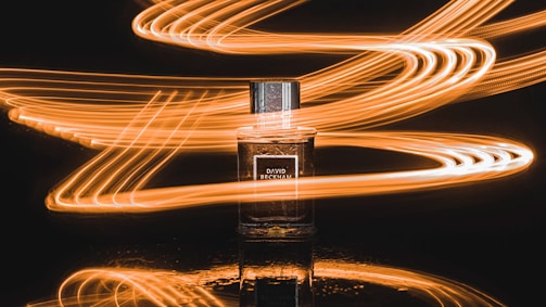 A delicate spritz of perfume mist catching the light in mid-air.