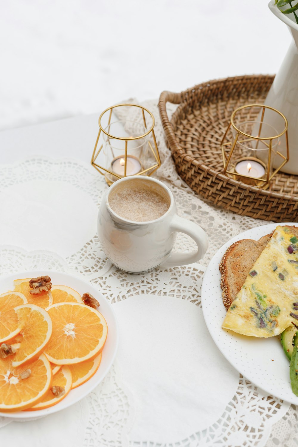 white ceramic mug with coffee beside bread on white ceramic plate