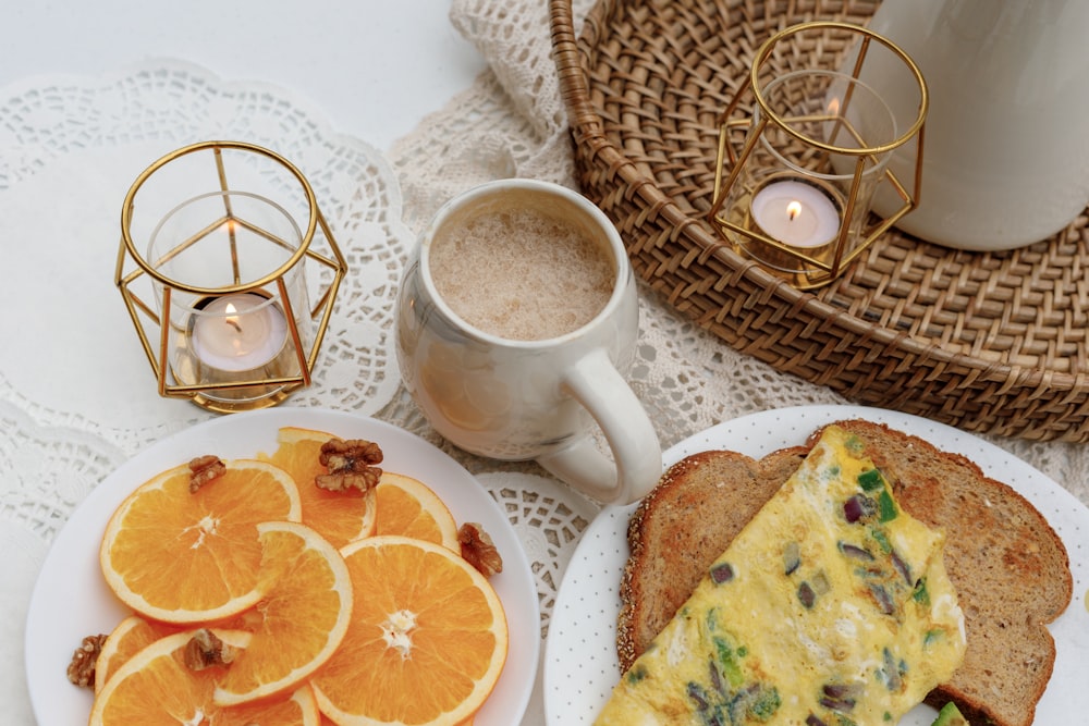 white ceramic mug on white ceramic plate beside sliced orange fruit