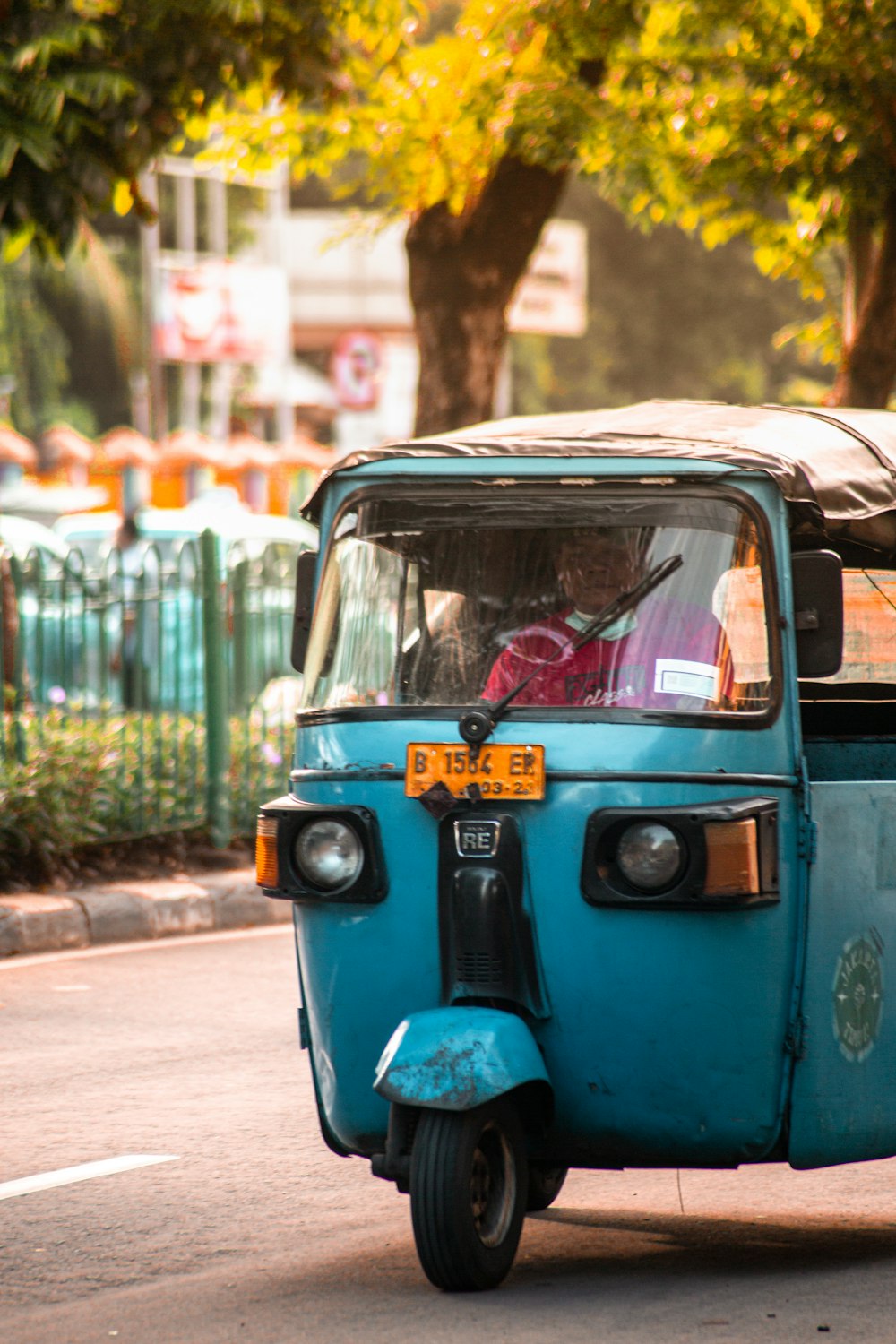 blue and black auto rickshaw on road during daytime