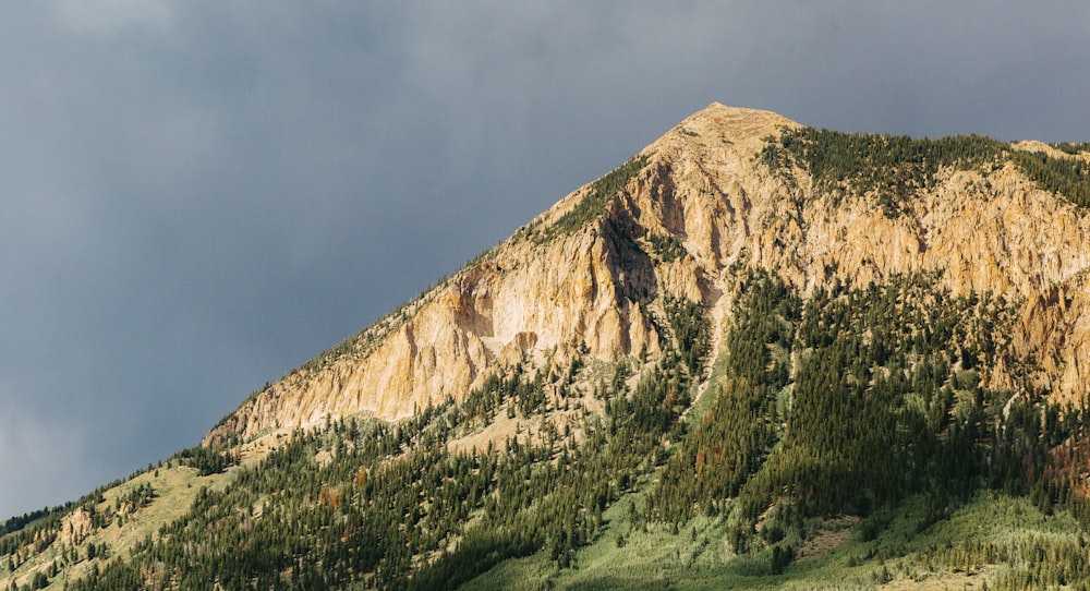 brown rocky mountain under gray sky