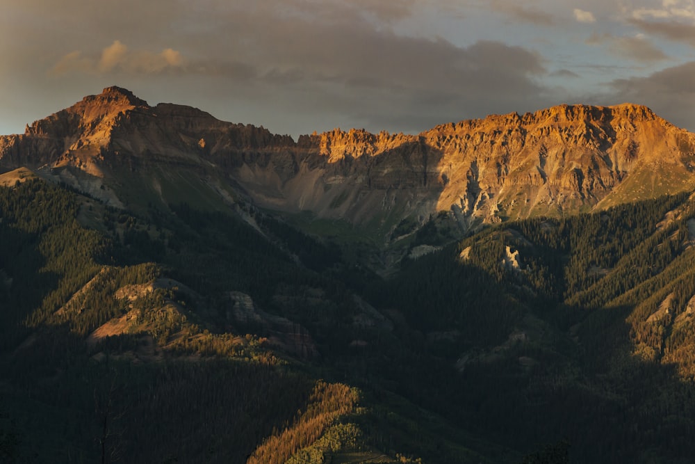 brown and green mountains under white clouds during daytime