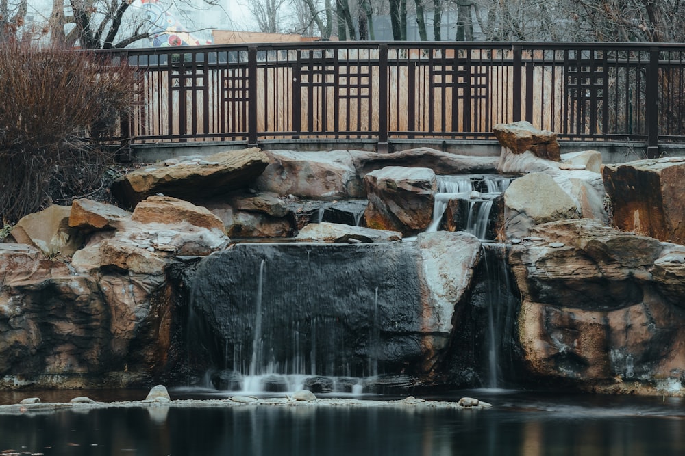 brown wooden bridge over water falls