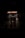 An entrance to a Japanese restaurant is seen with a glowing neon sign reading 'JAPANESE RESTAURANT.' Beneath, a green sign displays 'Sushi Yan' and the address '770 Thurlow St.' The image is dimly lit, creating a moody atmosphere.