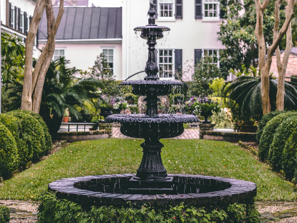 brown concrete outdoor fountain in front of white building during daytime