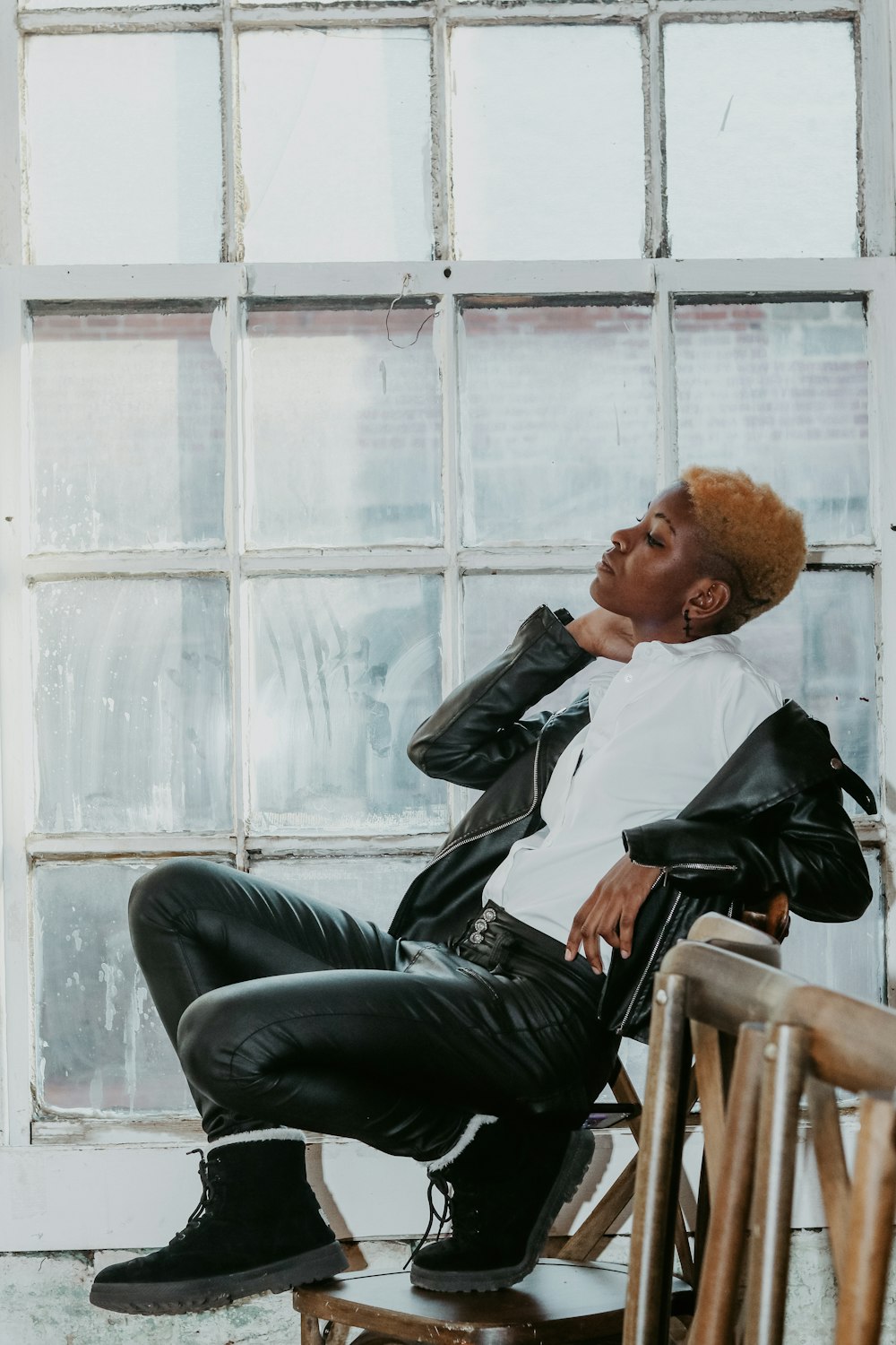 man in black leather jacket sitting on black leather armchair