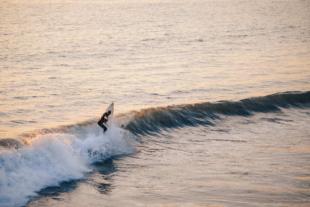 person surfing on sea waves during daytime