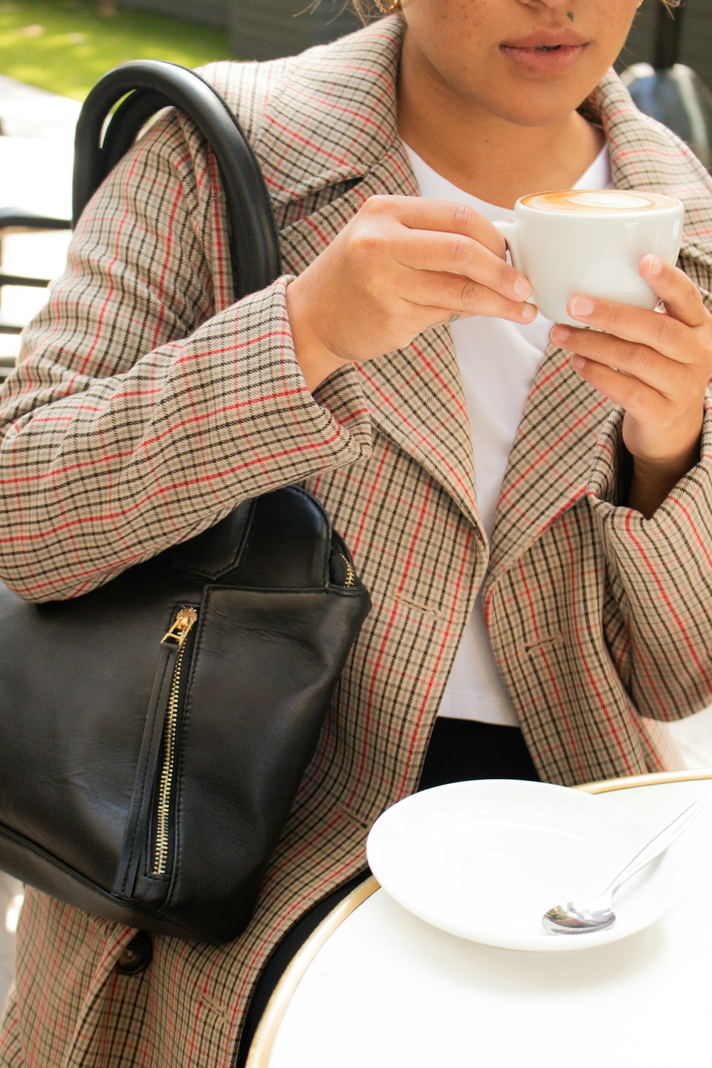 person in red and white plaid button up shirt holding white ceramic mug