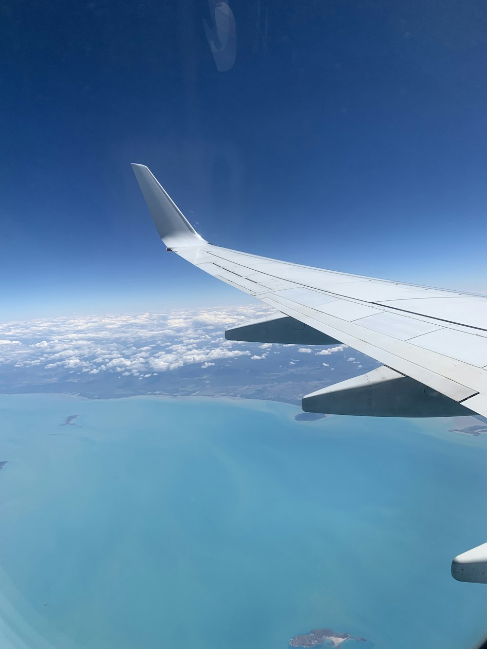 white airplane wing over the sea