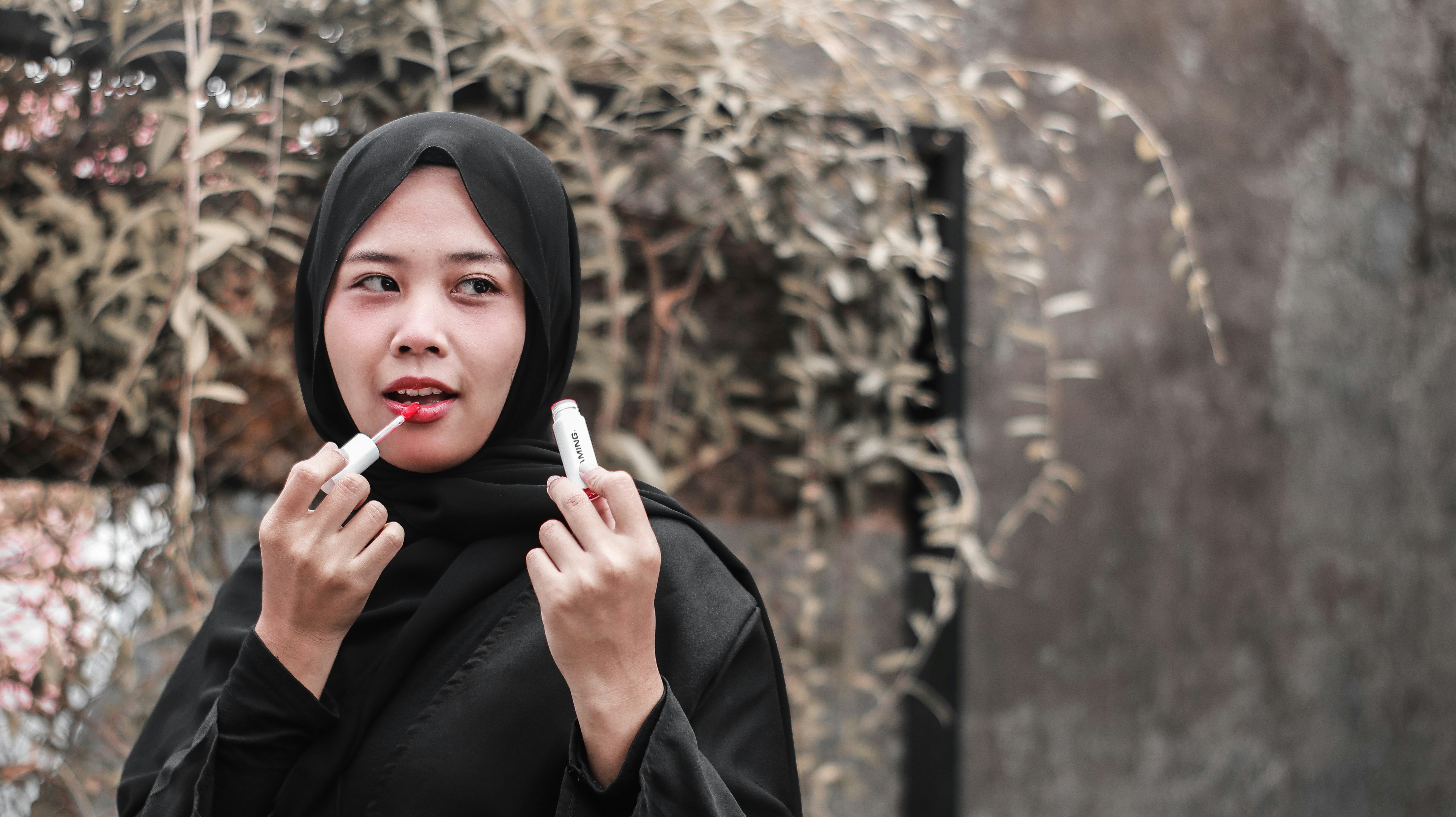 Woman in black hijab holding cigarette stick photo – Free Lipstick ...