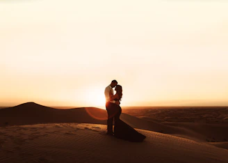 woman in black bikini standing on brown sand during sunset