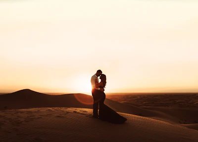 woman in black bikini standing on brown sand during sunset
