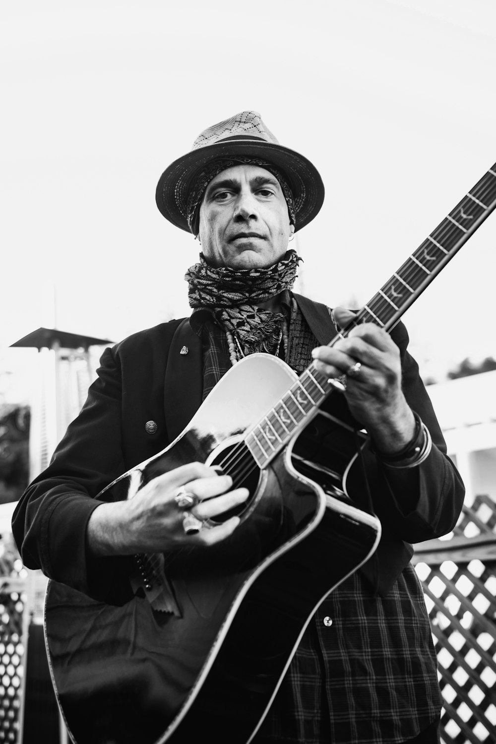 man playing acoustic guitar in grayscale photography