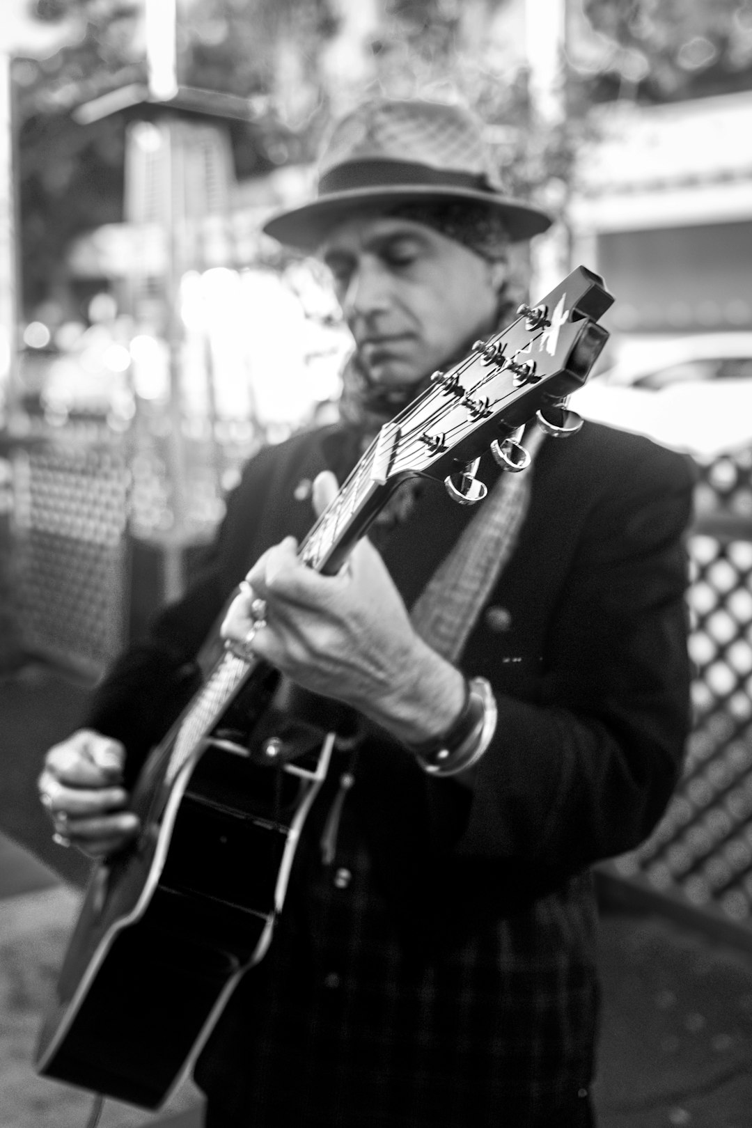 man playing guitar in grayscale photography