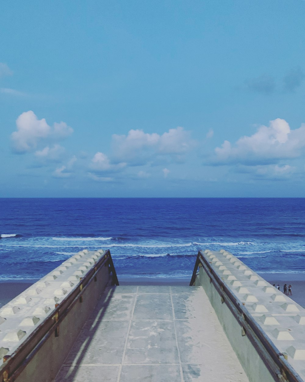 gray concrete dock near body of water during daytime