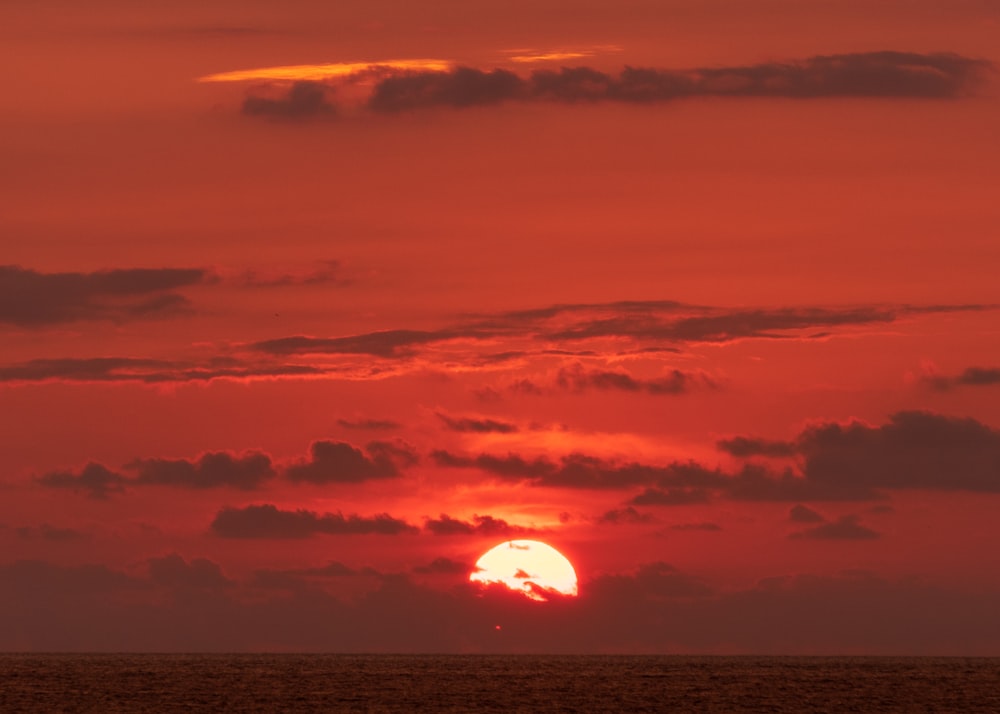 body of water under orange sky during sunset