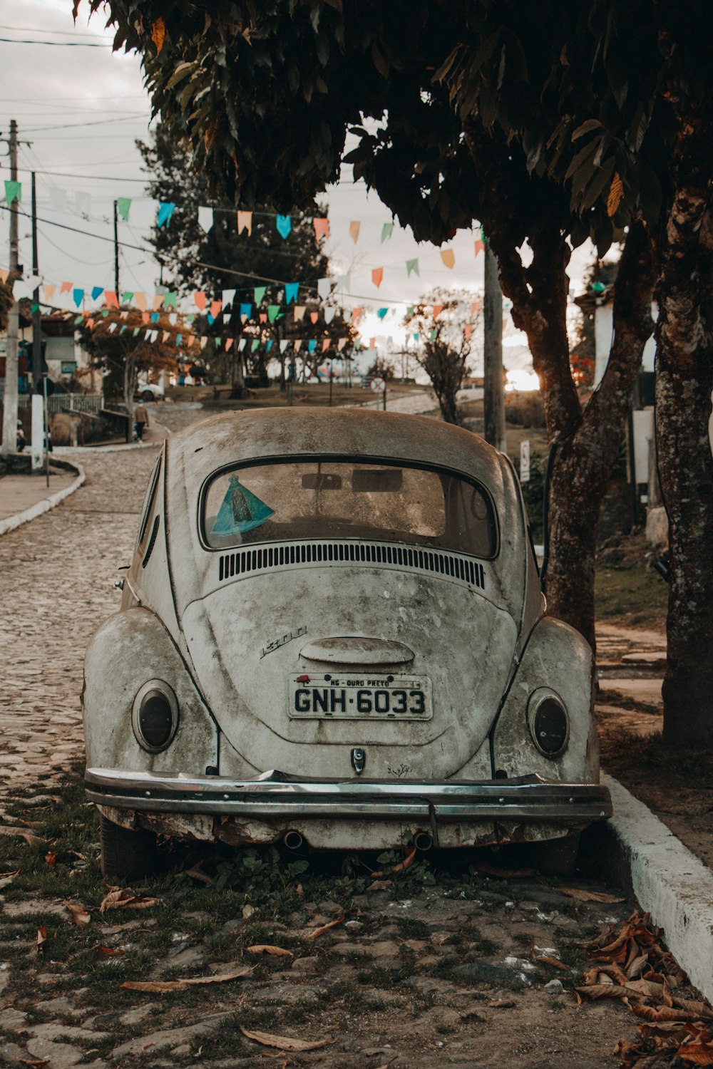 white volkswagen beetle parked on street during daytime