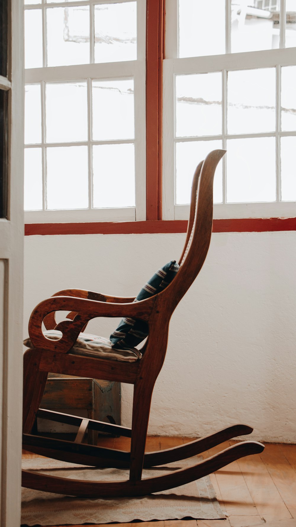 brown wooden armchair beside white wall