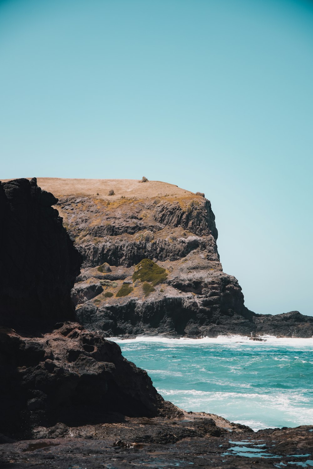 brown rock formation beside blue sea during daytime