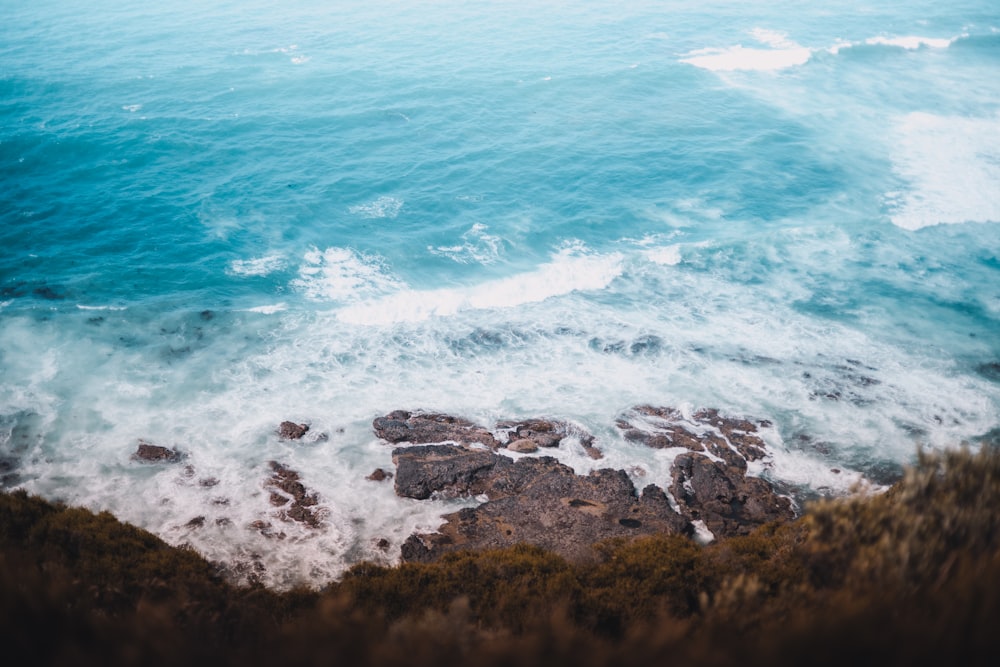 brown and green rock formation on sea during daytime