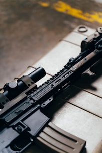black rifle on brown wooden table