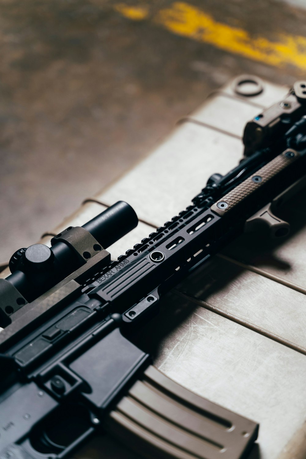 black rifle on brown wooden table