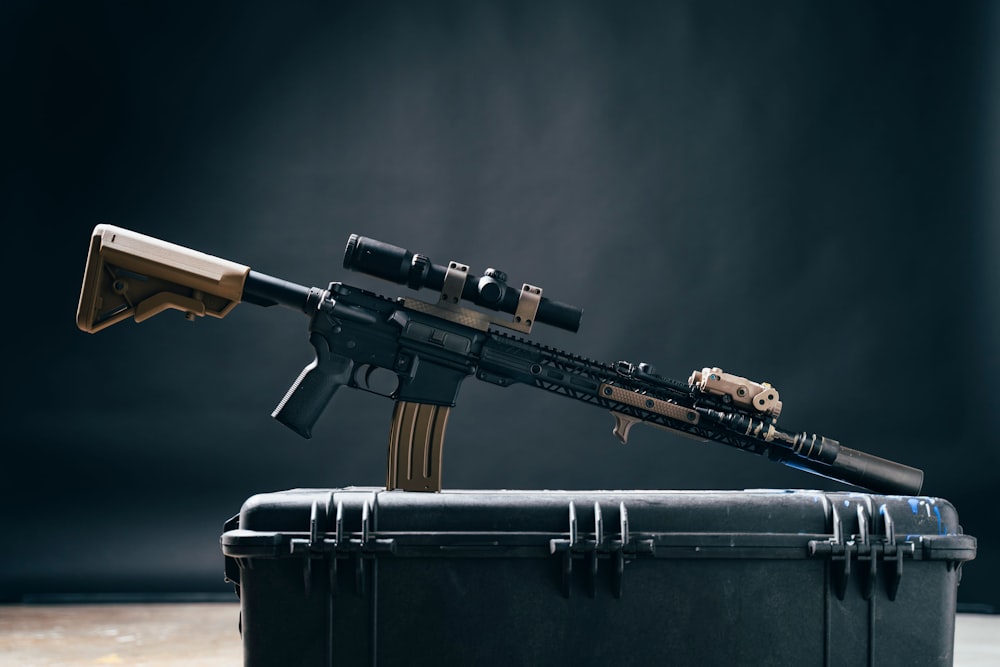 black and brown rifle on black leather suitcase