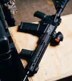 black rifle on brown wooden table