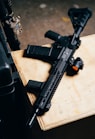 black rifle on brown wooden table