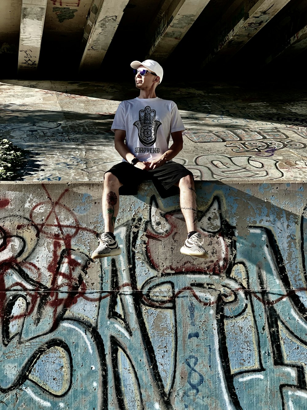 man in white crew neck t-shirt sitting on concrete bench during daytime