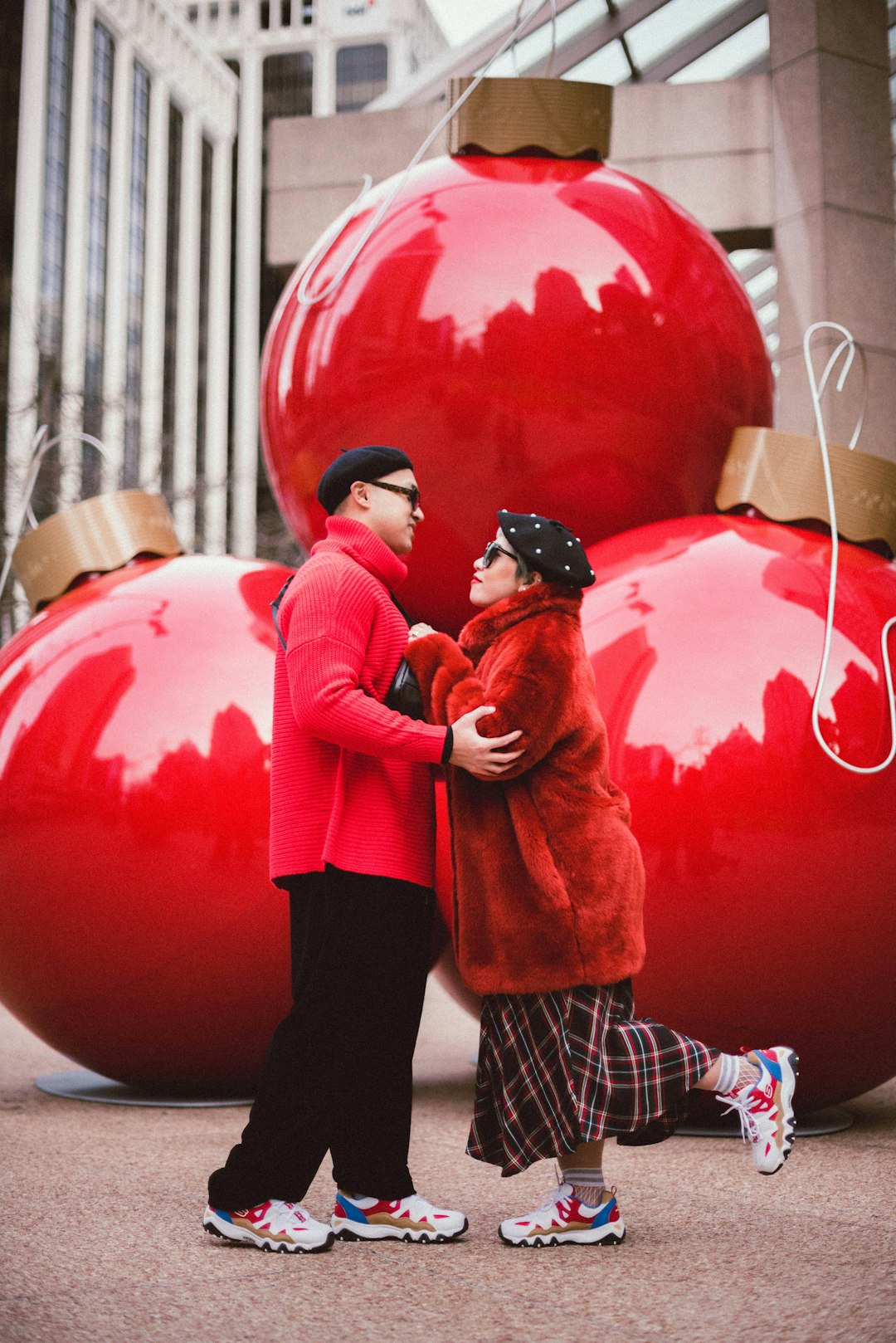 woman in red jacket and black pants carrying red heart balloon