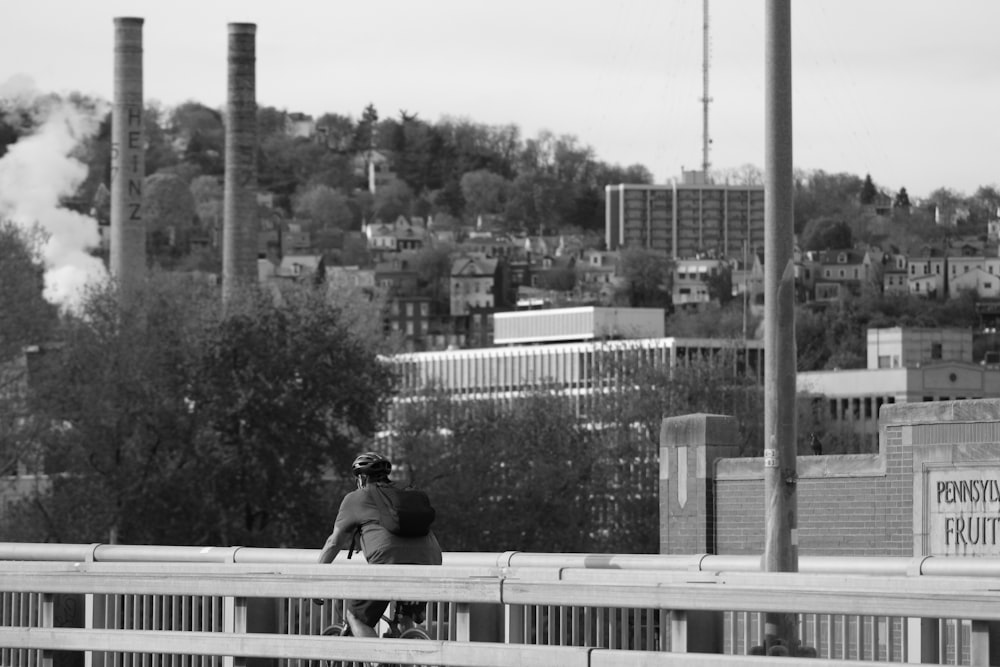 grayscale photo of man sitting on bench