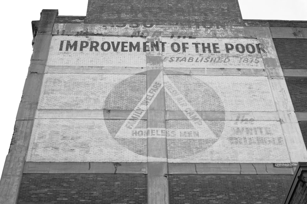 a sign on the side of a building that says improvement of the poor